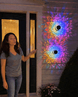 Solar mandala wall light glowing on outdoor wall