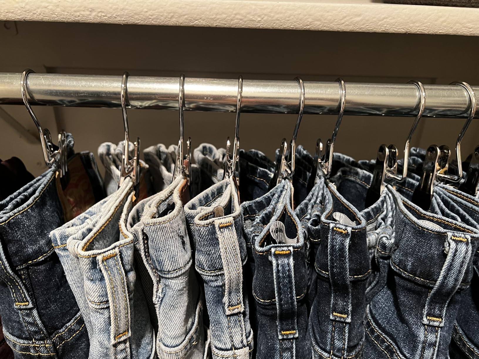 Jeans hanging neatly with metal clip hangers