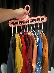 Pink space saving hanger holding multiple colorful clothes