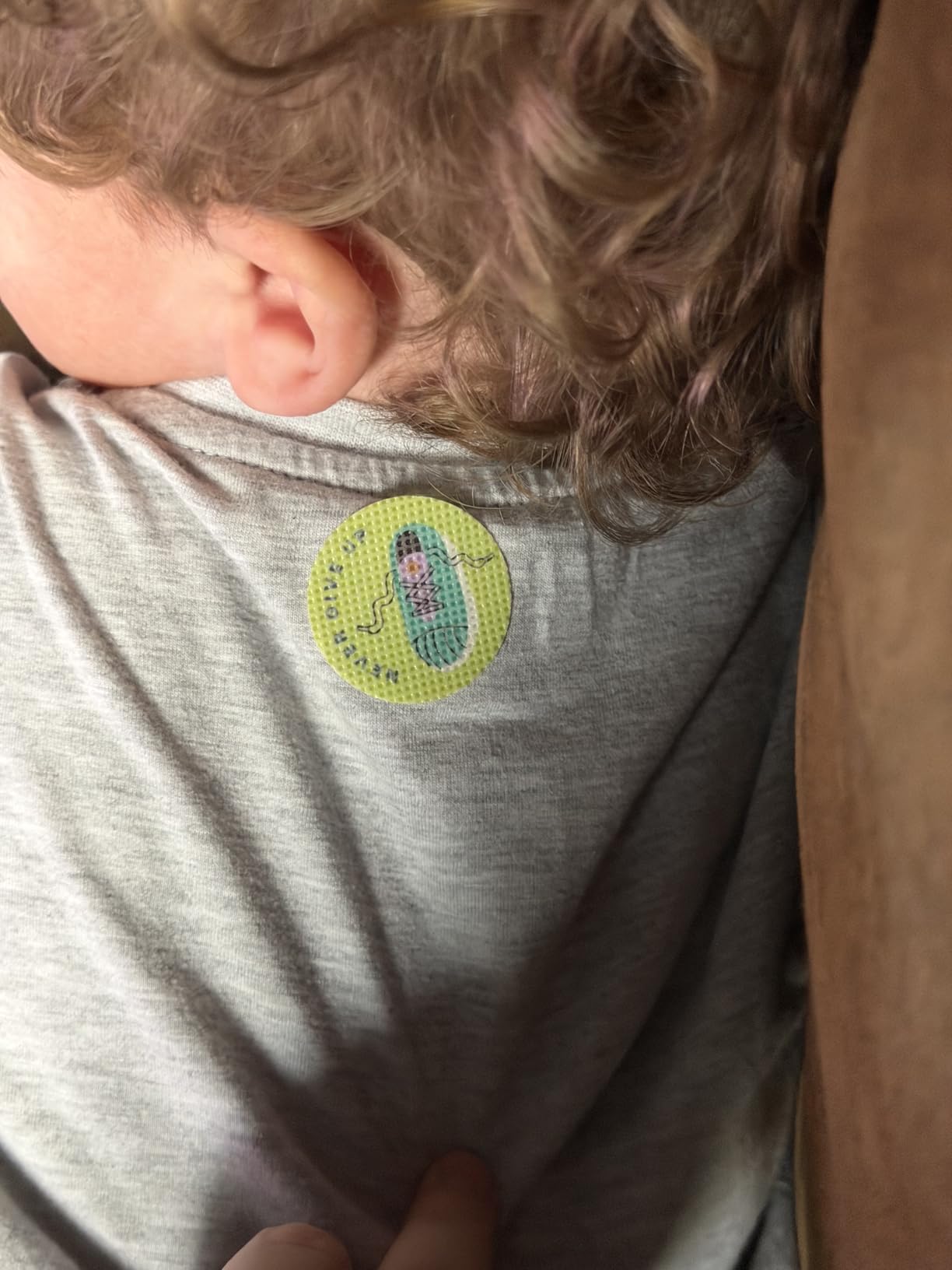Child wearing mosquito repellent sticker on the back of shirt